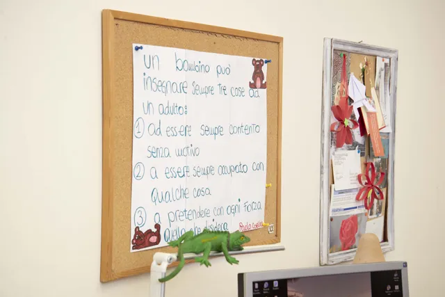 Lavagna di sughero con un pensiero scritto a mano e un camaleonte giocattolo