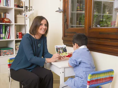La neuropsichiatra infantile Michela Caselli al tavolo con un bambino che disegna