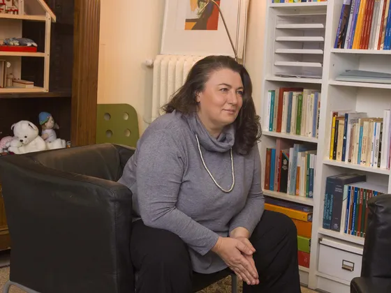 La psicologa Beatrice Fiorini seduta in poltrona, davanti alla libreria